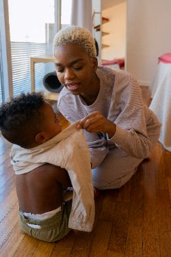 Parenting Peace: Proven Strategies for Managing Stress and Finding Balance 34 A mother dressing her child