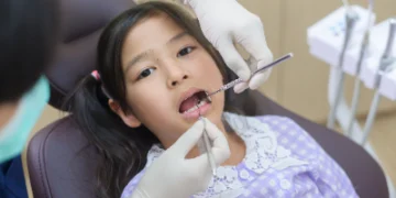 Sparkling Smiles: The Ultimate Guide to Children's Dental Health 30 A dentist observing a girl