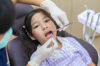 Sparkling Smiles: The Ultimate Guide to Children's Dental Health 34 A dentist observing a girl